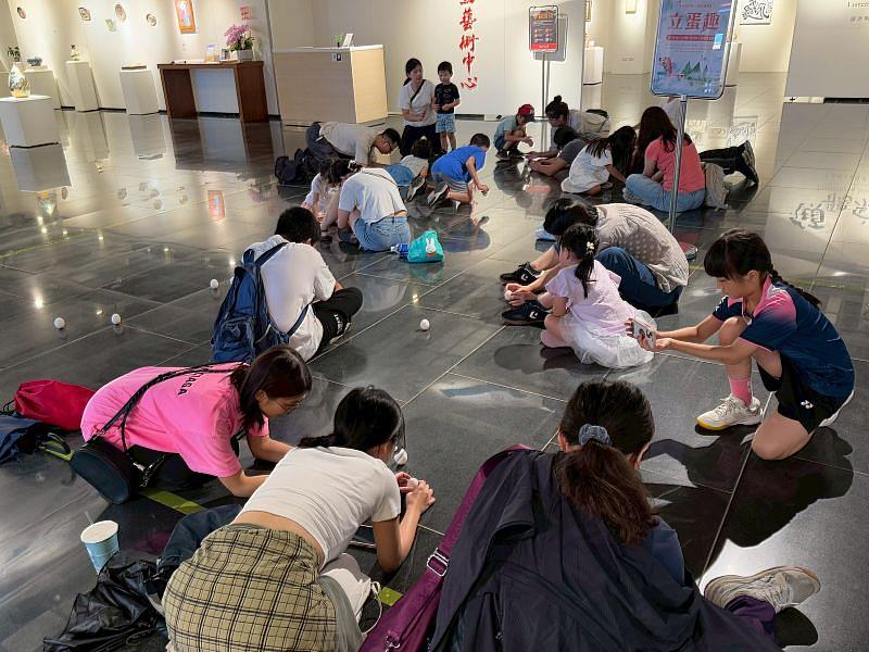 大小朋友齊聚一堂，屏氣凝神地將雞蛋立起。