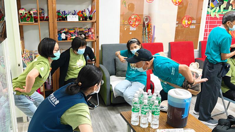 鄭進義老師（右）示範日常伸展與肌肉保健技巧，門諾基金會同仁及公益好友武琳琳一同學習。