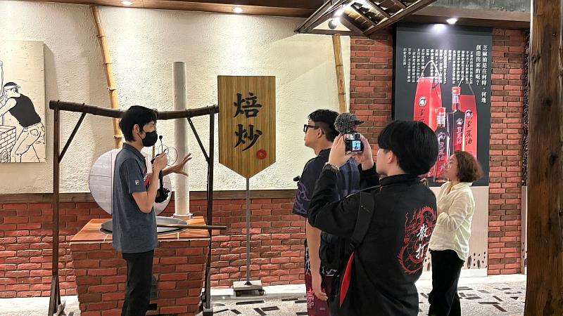 新加坡NYP學生實地走訪西港「胡麻嫂故事館」，專注聆聽傳統胡麻焙炒製程介紹，深入採集在地產業的常民生活素材。