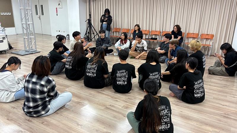 新加坡NYP團隊觀摩南臺流行音樂產業系發展中的音樂劇作品，兩校學生席地交流，深入探討角色、場景與舞台節奏的設計方向。