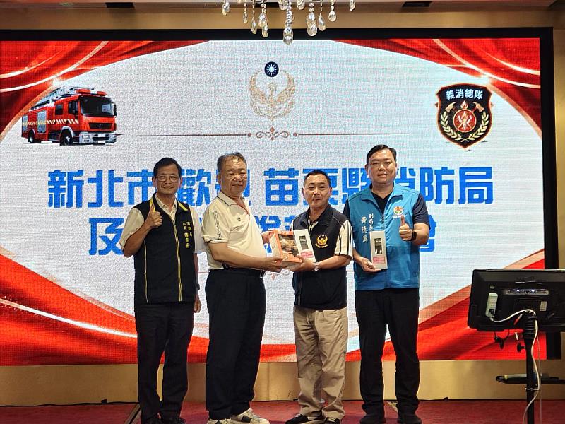 新北市義勇消防總隊總隊長蔣根煌（左2）代表致贈紀念品予苗栗縣義勇消防總隊副總隊長李運金（右2），新北市政府消防局局長陳崇岳（左1）及苗栗縣消防局副局長黃德興（右1）共同見證。