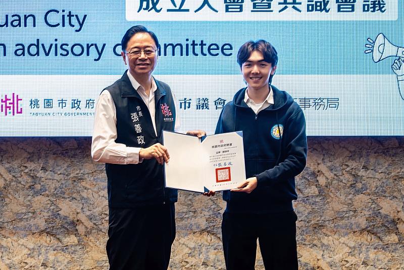 桃園市長張善政（左）頒發桃園市政府第7屆青年諮詢委員聘書予中山醫大醫管系學生鍾靖亭。