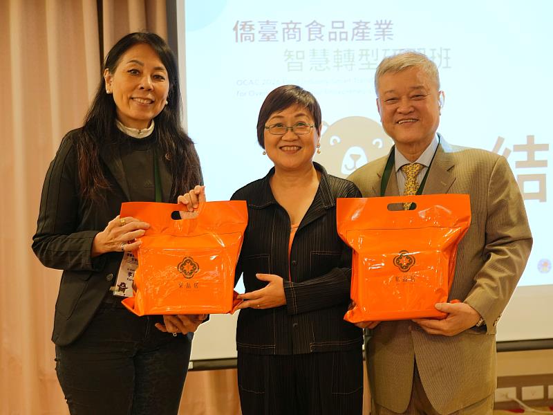 僑委會致贈研習班禮品，由學員長楊必誠及副學員長李欣芬代表領取。