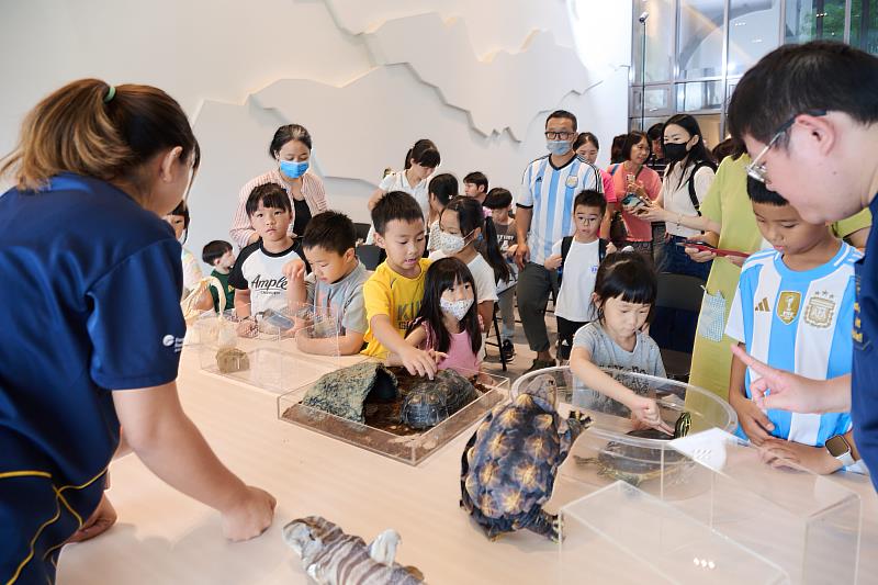遠雄海洋公園保育員與學童分享，與烏龜互動時需輕撫背殼，避免使生物受到驚嚇