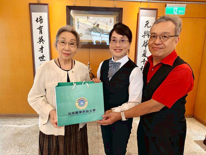 蔡雅賢董事長(左)回贈學校60週年專書等紀念品給劉惠安及簡淑賢校友