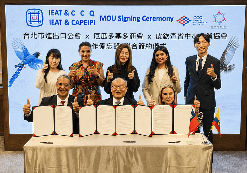 IEAT秘書長黃文榮（前排中）與CCQ會長Ms. Mónica Heller（前排右）、CAPEIPI會長Mr. Francisco Vergara（前排左）代表簽署MOU。IEAT貿易推廣處處長方芬美（後排中）、CAPEIPI營造部副主席Ms. Lorena Caicedo（後排左2） 、CCQ技術暨專案主任Ms. Evelyn Chiriboga（後排右2）與外交部隨員出席見證觀禮。