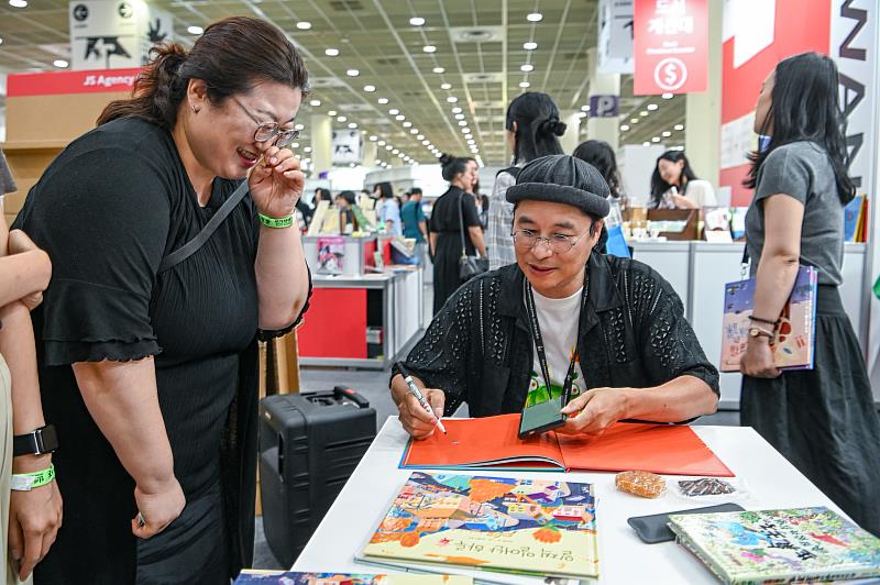 賴馬於講座後為讀者簽繪，現場互動熱絡、笑容洋溢。（文策院提供）