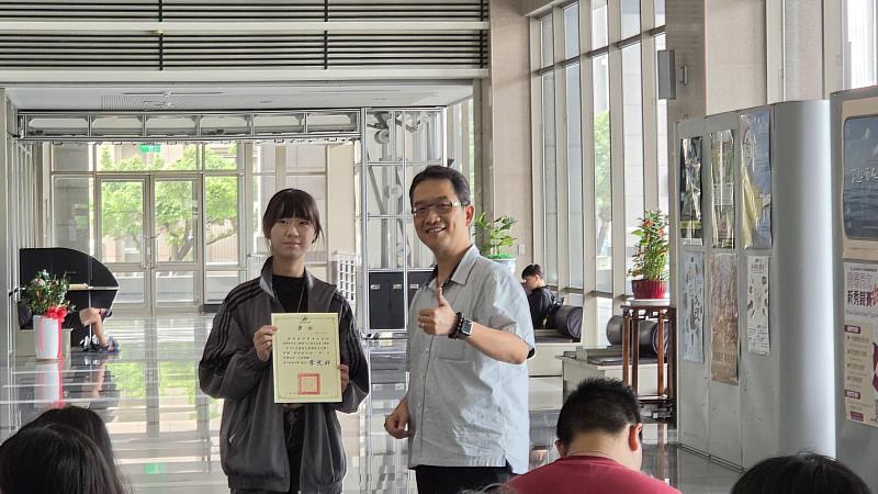 葉仲超主任(右)與新詩創作組首獎公廣系楊筑甯(左)合影。