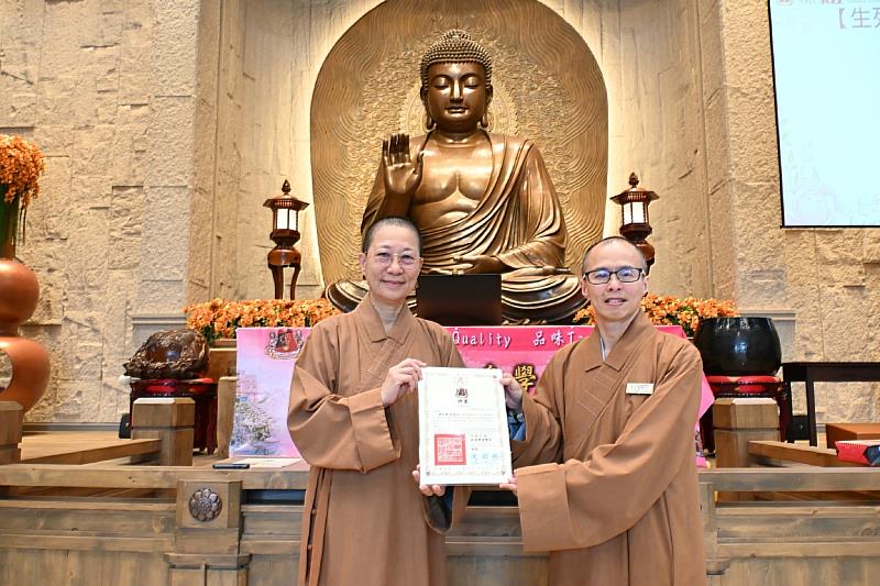 辦訓單位佛光山月光寺住持妙勳法師(左)頒發聘書及感謝狀予主辦單位南華大學終身學習學院院長釋知賢教授(右)。