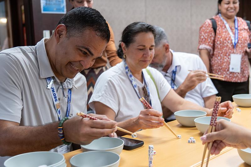 Delegates test their skills in a chopstick challenge (Photo courtesy of Jehovah’s Witnesses).