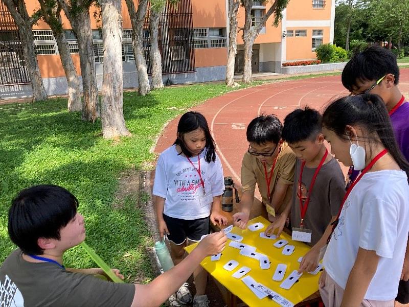 大手牽小手！元培醫技系學生帶虎林國小學童玩科學前先分組。