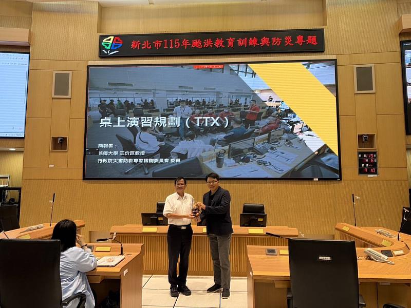 消防局陳崇岳局長致贈宣導品予銘傳大學王价巨教授。