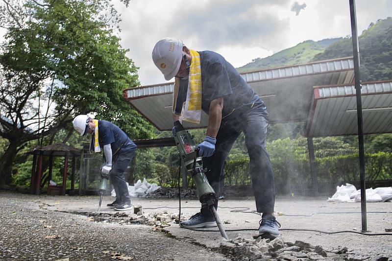 東源營造同仁打鑿路面，將破損範圍的邊界進行整理，以便後續進行泥作工程。