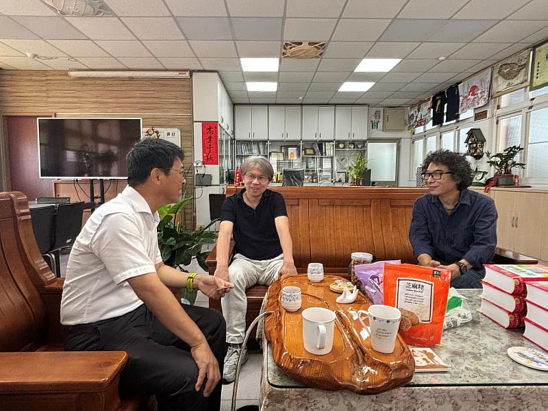 顯宮國小何志中校長(左)介紹國小特色及討論合作方向