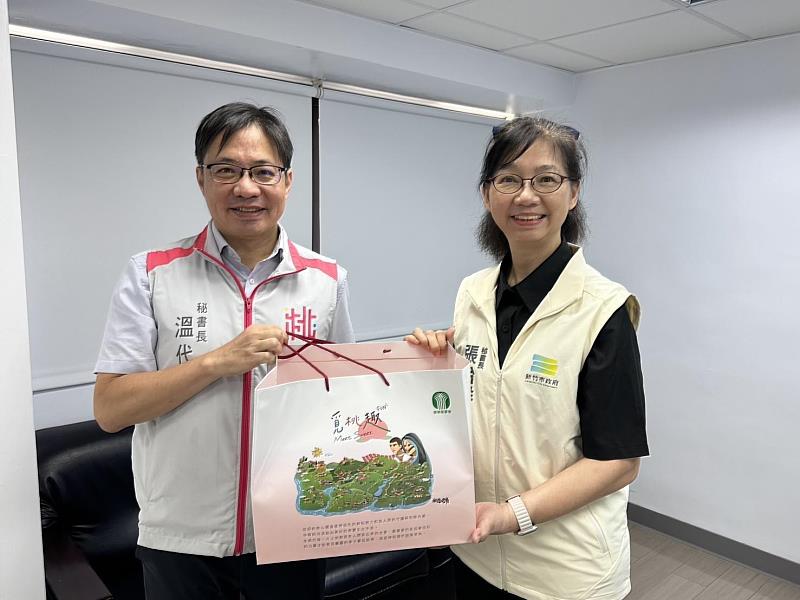 桃園市政府秘書長溫代欣致贈紀念品予新竹市政府秘書長張治祥。