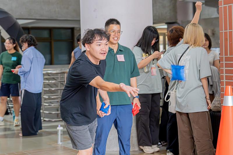 來自不同單位的學務同仁混合分組 學務處同仁全神貫注後抛出布袋球。