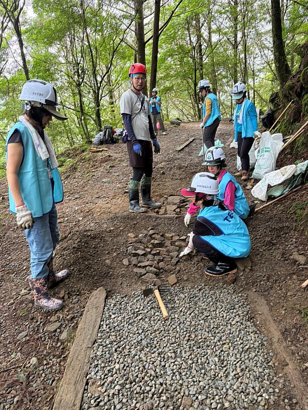 員工齊心協力將路面回填夯實及挖掘導水溝,以解決古道積水與泥濘問題。