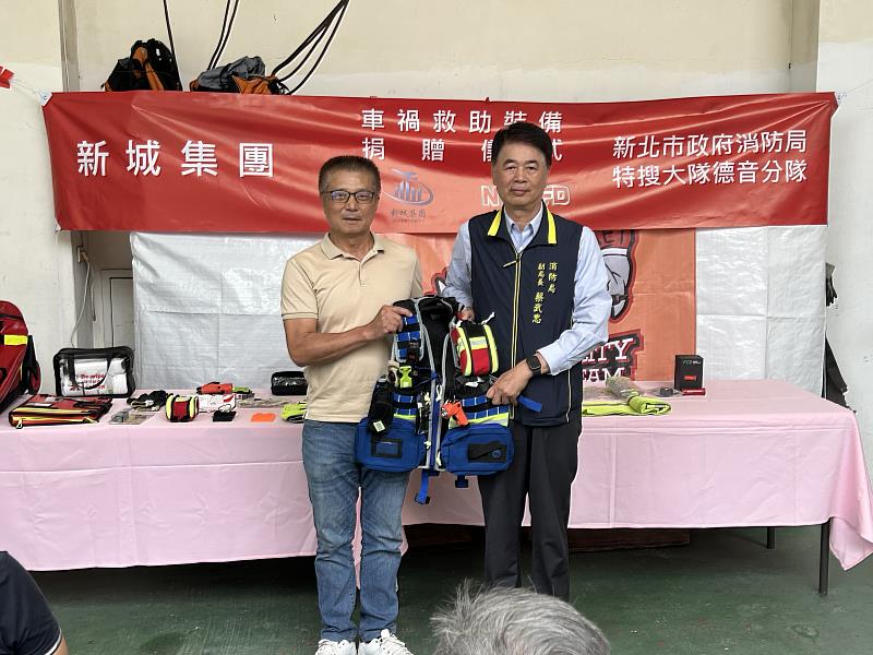 左為新城營照董事長劉洲延,與副局長蔡武忠(右)車禍救助裝備合照。