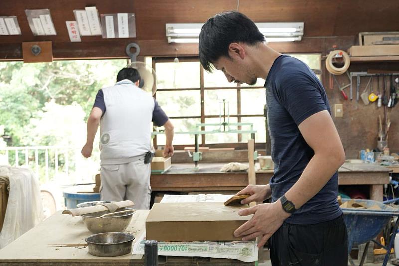 山本瓦株式會社瓦作匠師操作傳統瓦片修整。