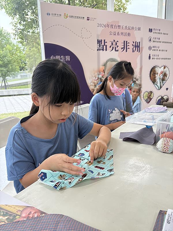 許多家長帶著孩子來到台塑王氏昆仲公園，參與這場別具意義的「親子共縫」活動。在講師的引導下，孩子們低著頭，專注地一針一線縫製布衛生棉。