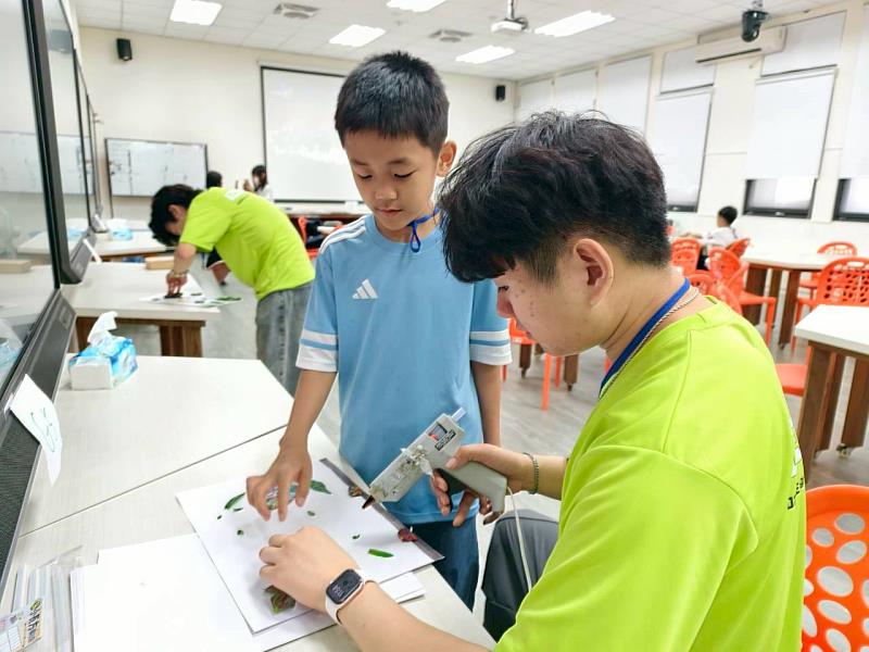 志工協助學生進行大自然藝術創作。