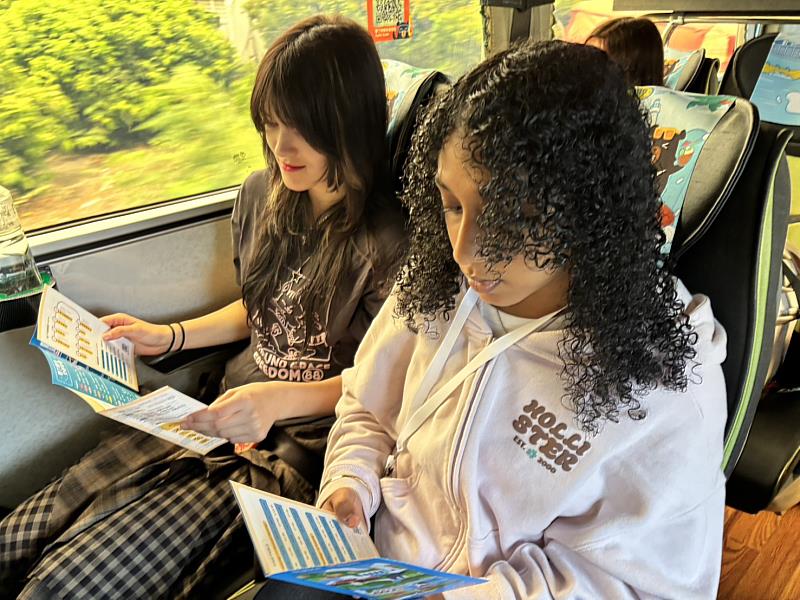 參與者於車上閱覽雙語旅遊路線摺頁，了解沿線觀光資訊
