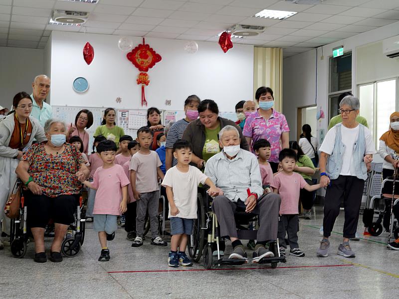 咪咪幼兒園小朋友牽著阿公、阿嬤的手，一起前往下一個闖關關卡，跨世代互動自然熱絡。
