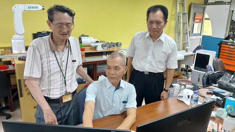 陳銓富（中）向指導教授陳國泰（左）、趙全鋐（右）示範系統。