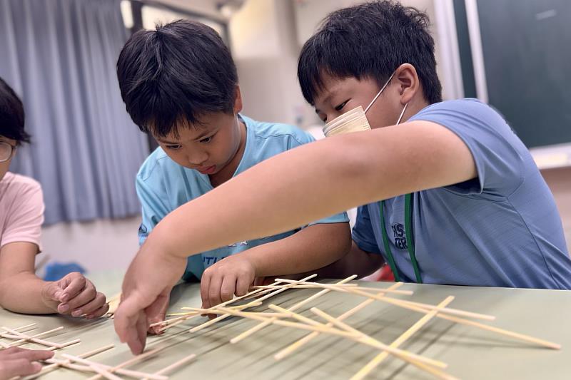 南大USR科學營引導學童搭建達文西拱橋，透過團隊合作探索結構力學原理，培養科學探究與實作能力。