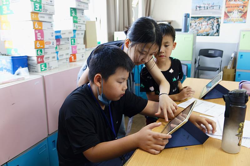 南大學生陪伴後港國小學童操作平板進行數位學習，透過科技探索家鄉文化，培養自主學習與問題解決能力。