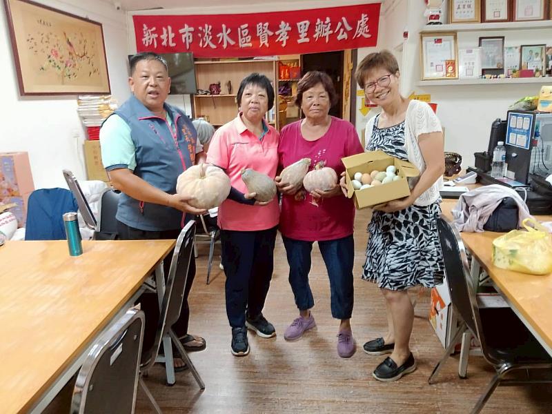 鍾秀琴主任（右1）將校園南瓜致贈賢孝里辦公處，與葉振昌里長（左1）及里民分享豐收成果與溫暖情誼。