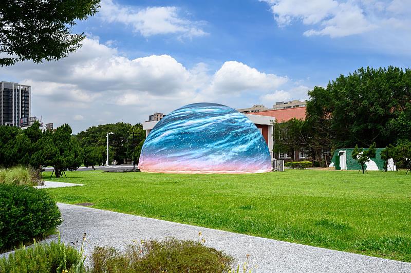 穹頂劇場外觀配合「FUTURE VISION LAB@晴空季」推出地景作品《晴穹：晴空下的破曉旭日》，將穹頂化為落地的天體，象徵開放天空與觀看想像的交會。圖／王世邦攝影、C-LAB提供