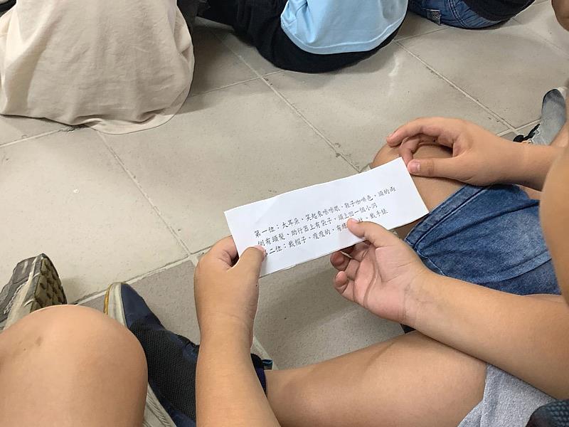每組孩子手持「神祕提示紙條」,上面寫著現場阿公阿嬤穿戴的特徵。