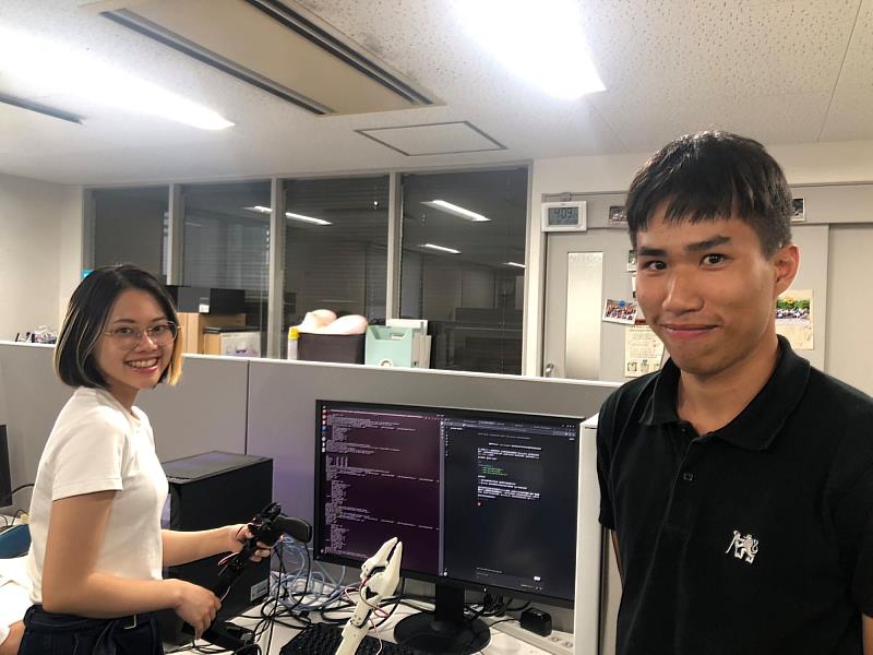 計畫團隊成員於大阪大學研究室操作機械手臂與AI程式進行實作測試。