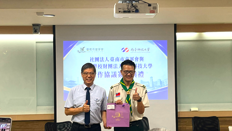 簽約儀式中雙方互贈紀念品,由南臺科大副校長王振乾(左)致贈紀念品予臺南市童軍會理事長楊智雄(右)。