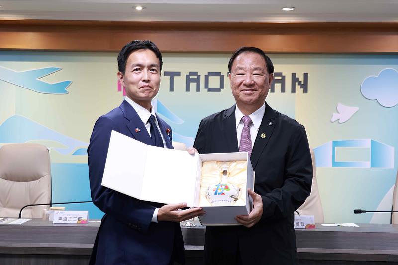 救國團葛永光主任與日本自民黨青年局長平沼正二郎交換紀念品。