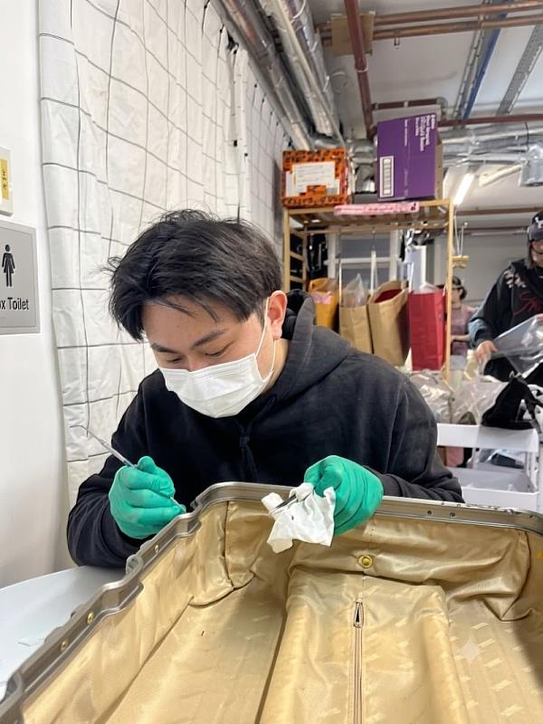 南臺科大產設系學生李悅誠於澳洲實習期間，專注進行精品硬殼箱的細部修復工序。