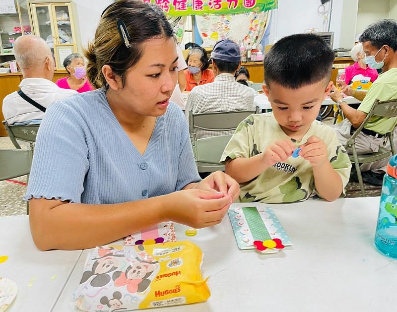 家長陪伴孩子專注進行父親節卡片裝飾與手作。