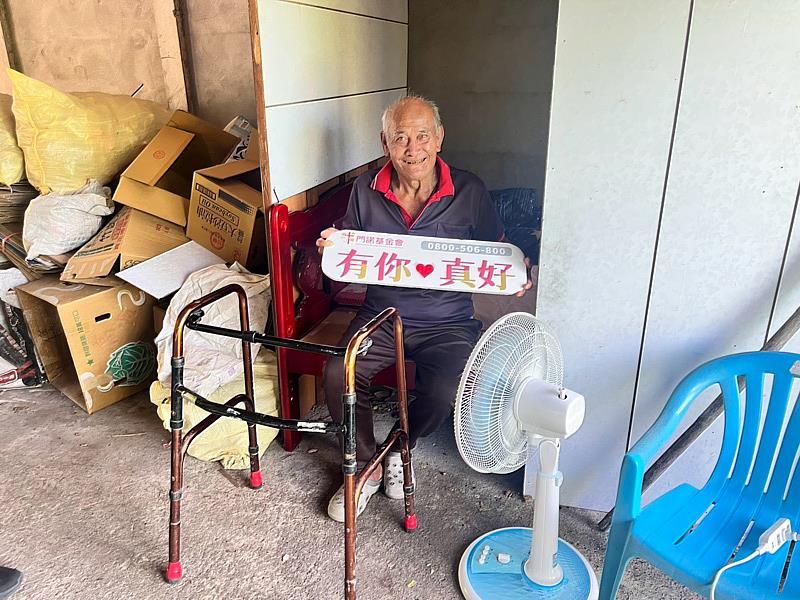 臺東縣東河鄉74歲姜伯伯，開心坐在房間門口與電風扇合影。