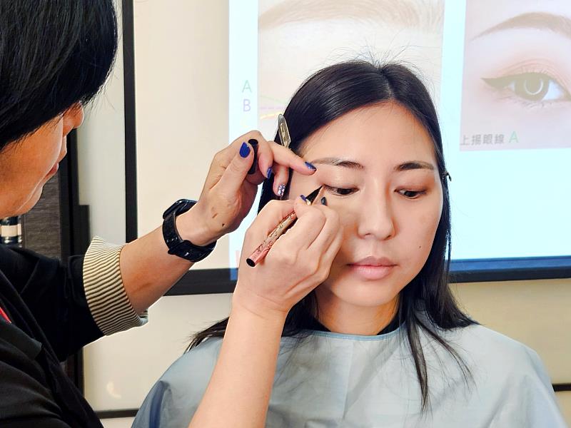 專業彩妝老師在「奇馨協力.公益彩妝教室」中,示範抗暈眼線畫法,帶領學員打造持久眼妝。(資料來源:台灣奇士美)