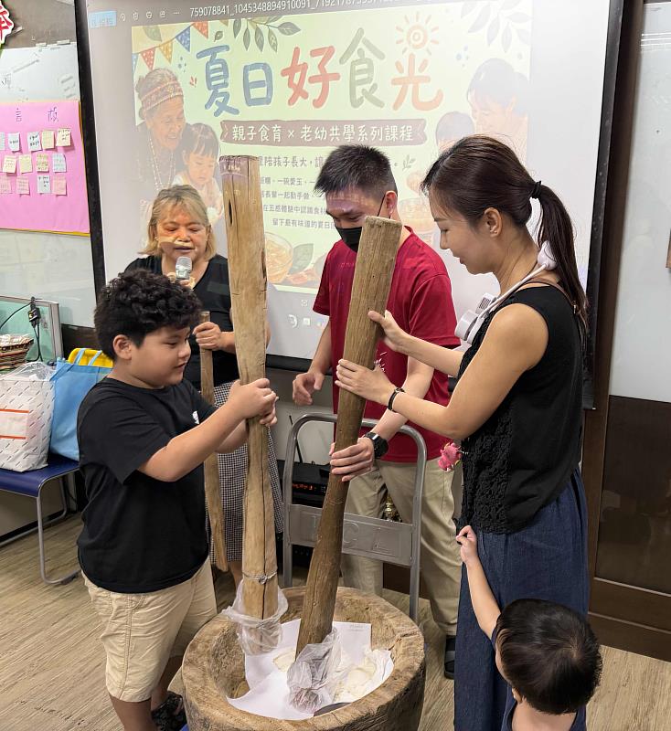 伊甸仁武據點舉辦「夏日好食光」系列課程,現場親子合力舉起木杵,體驗原住民傳統搗麻糬。