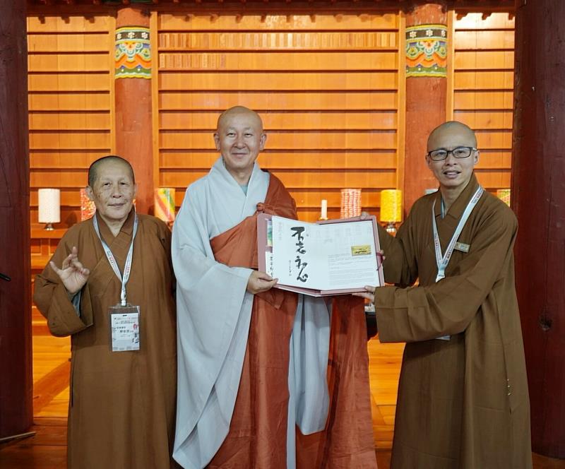 南華大學終身學習學院「33觀音巡禮」三部曲，知賢法師（右）、依恩法師（左）致贈星雲大師「傳燈六十．百年仰望」紀念郵票予第15號觀音聖地雙磎寺住持指玄法師（中），深化臺韓佛教文化交流。