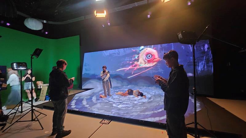 南臺科大資傳系學生於新加坡Beyond Reality Studio虛擬攝影棚現場執行拍攝,在LED虛擬場景中精準調度實體燈光與攝影鏡頭,展現虛實整合影像製作專業。