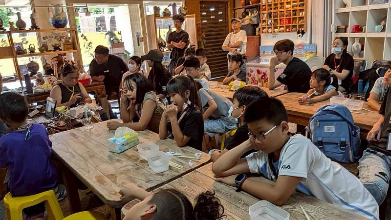 學童們認真投入活動之中，專注聆聽講師的陶盤彩繪說明。
