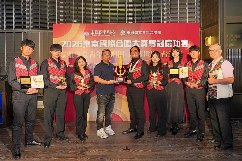 慶功宴現場展示奪冠獎座，中保科技董事長林建涵（左4）、指揮徐惟遠老師（右4）與泰雅學堂徐榮春校長（右1）及手持各項金獎獎牌的學生代表合影留念。