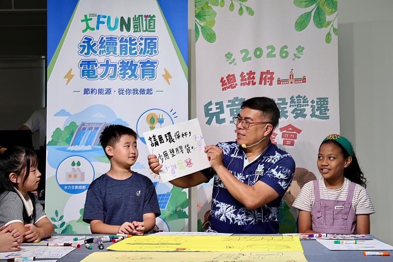 環境部長彭啓明參加了兒童氣候變遷高峰會，拿起小朋友「請用環保杯、少用塑膠袋」的倡議海報。