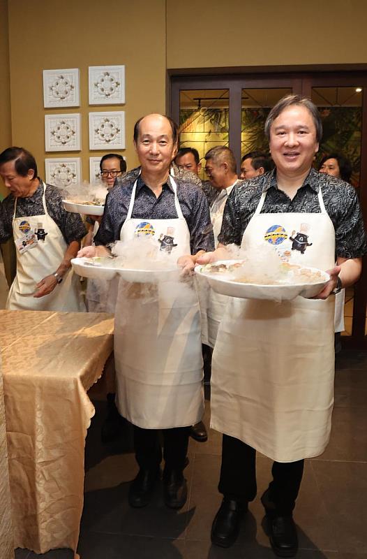 汶萊臺灣商會吳家鑫會長（右）、僑務顧問麥順成（左）率汶萊臺灣商會理監事團隊於「上菜秀」環節端上佳餚，親自為賓客上菜。