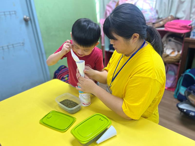 陳韋彤陪伴幼兒進行操作活動，在互動中引導孩子探索與學習。