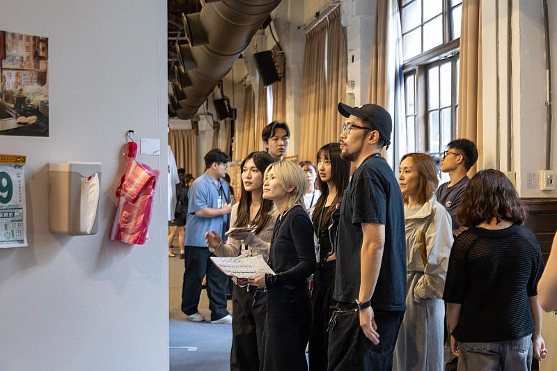 世新大學圖傳系畢業展《年筋人》展出期間,李芹羽(前排左)、曹書睿(前排右)與學生交流作品創作構想。(世新大學提供)