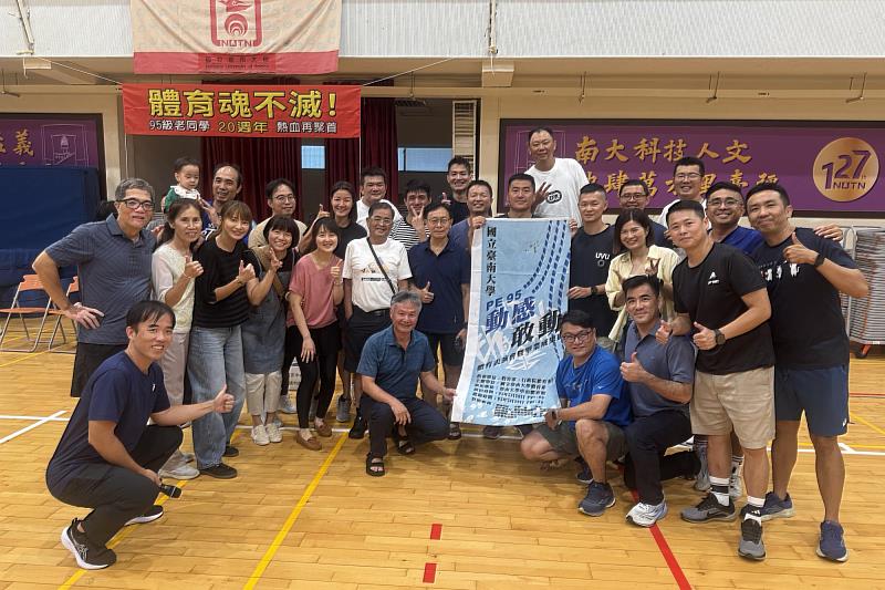 南大95級校友帶著畢業成果展旗幟重返母校，與師長同窗合影見證跨越20年的情誼。